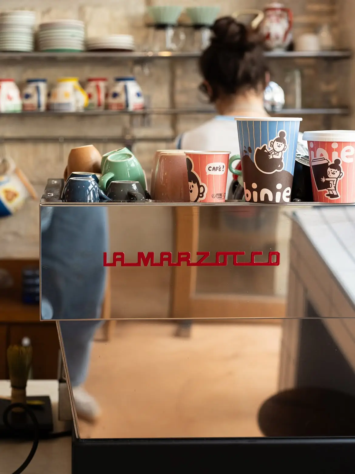 Gobelets Binie réutilisables posés près de la machine à café