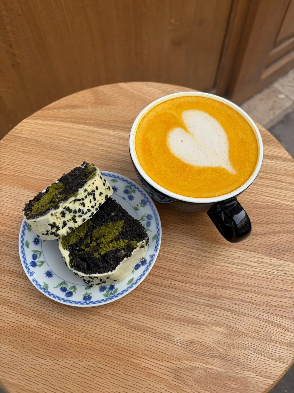 Golden latte et deux parts de cake matcha et sésame noir en terrasse