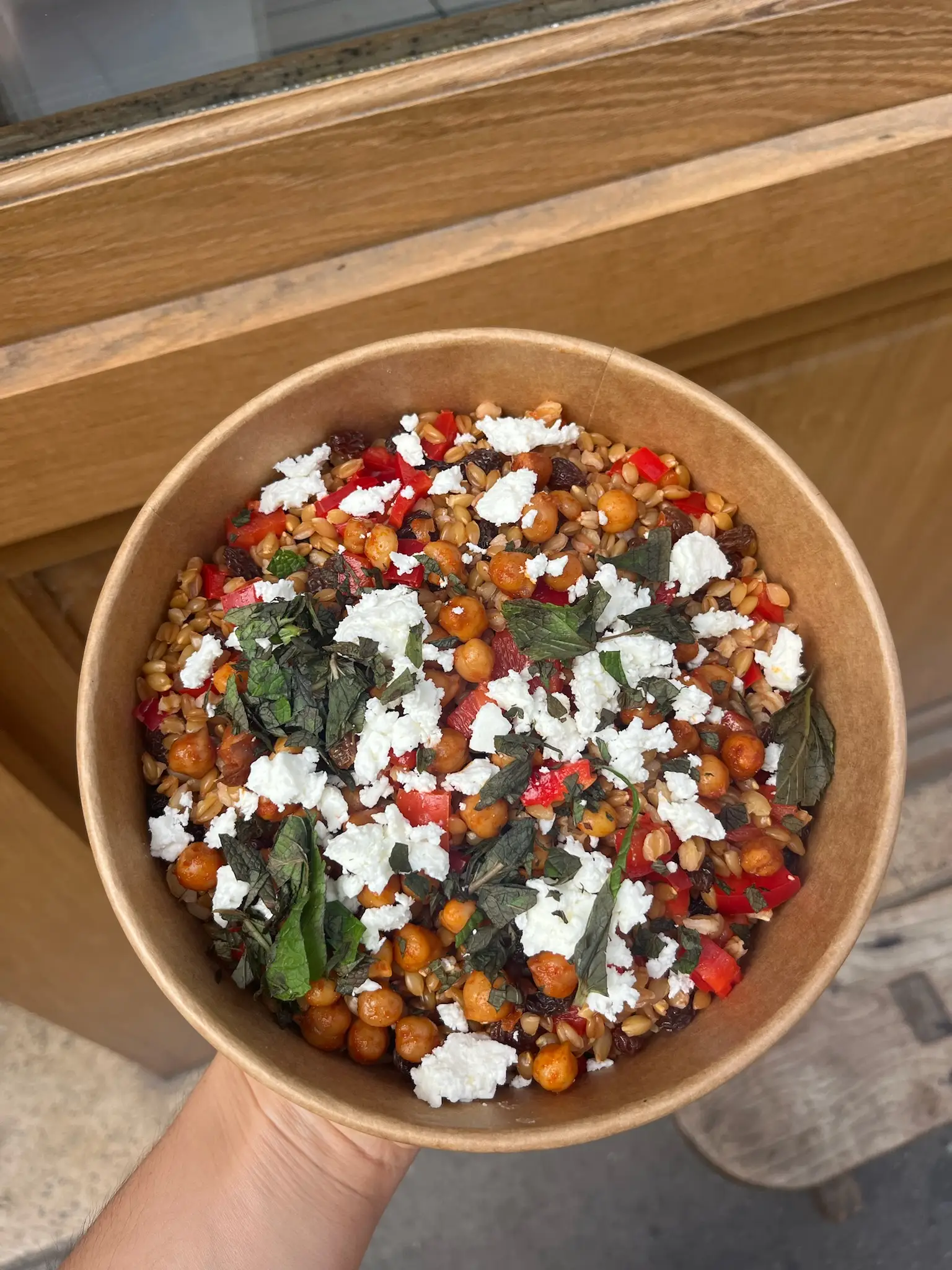 Salade de pois chiches, feta, poivrons et herbes fraîches dans un bol à emporter, chez Binie