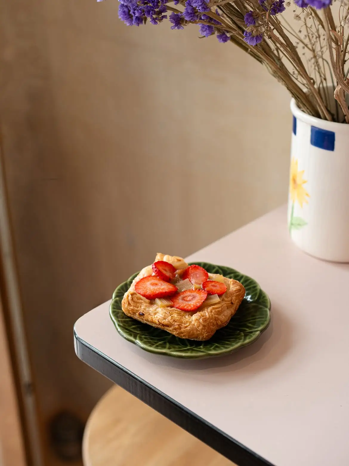 Une tartelette aux fraises sur une assiette en forme de feuille