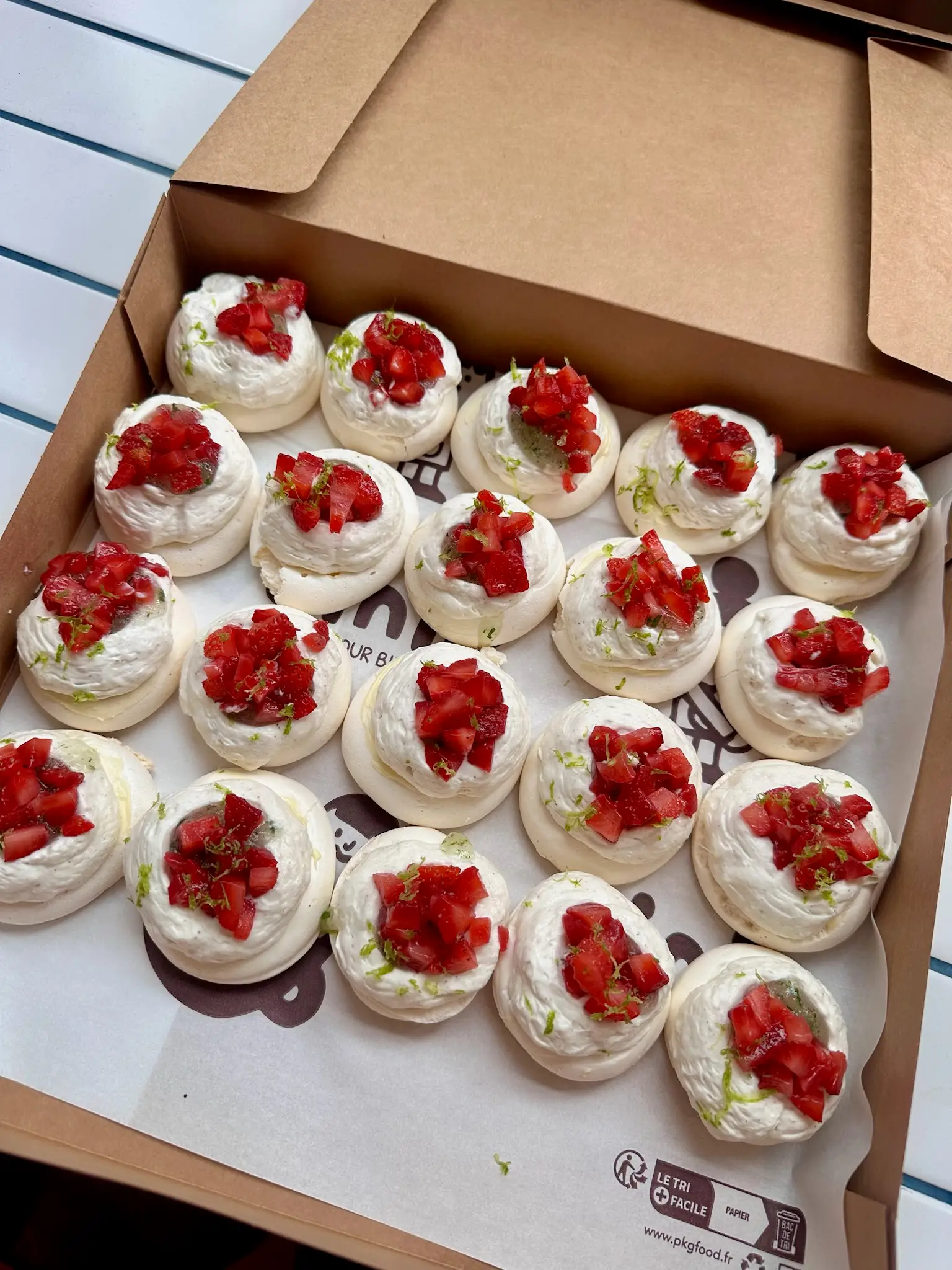 Grand plateau d’une vingtaine de pavlovas aux fraises préparées par Binie pour un événement